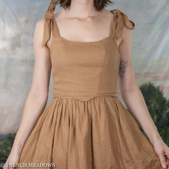 model wearing light brown bustier top with matching linen skirt