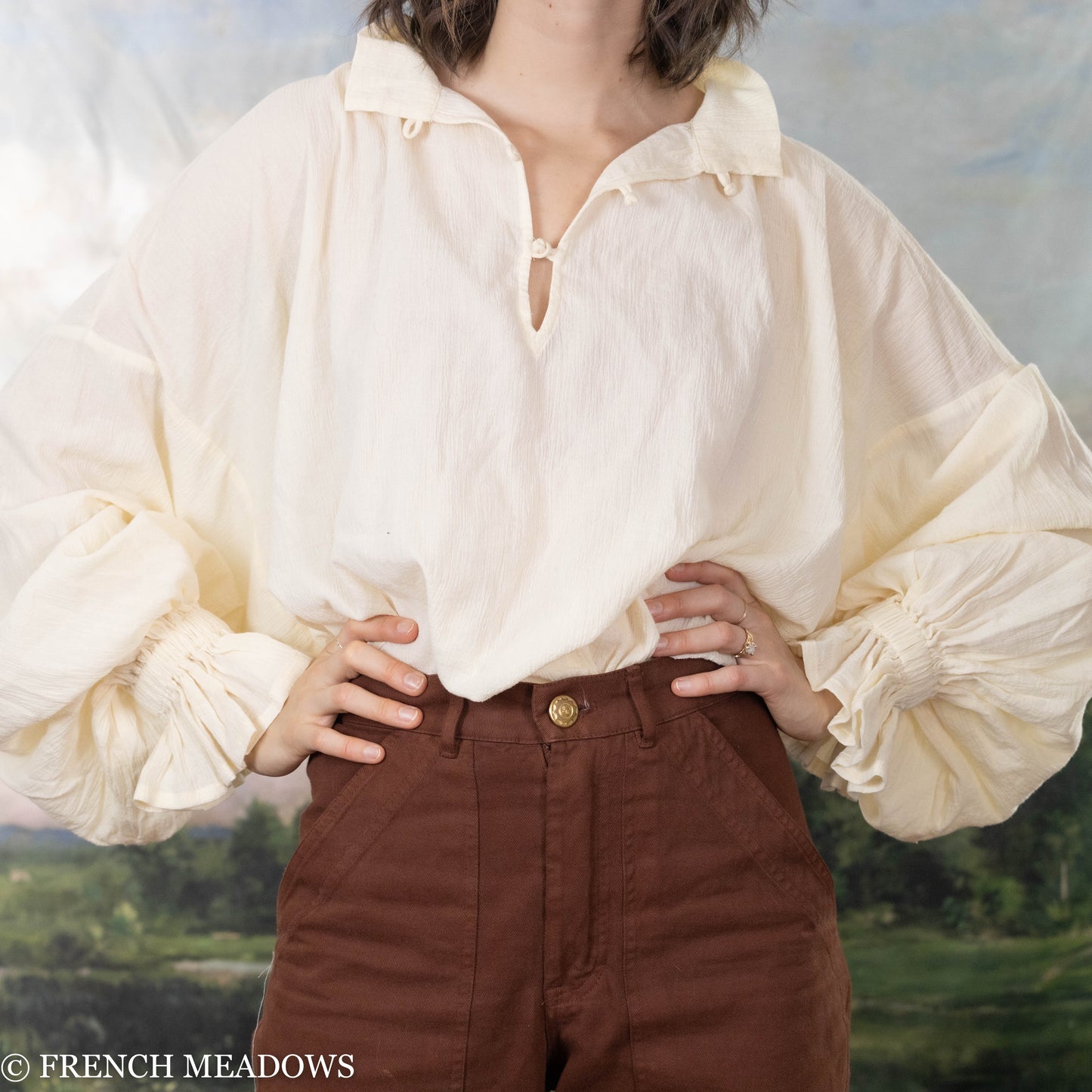 model wearing french meadows womens poet blouse tucked into brown pants