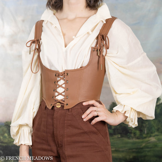 female model wearing pirate shirt layered under a leather underbust corset