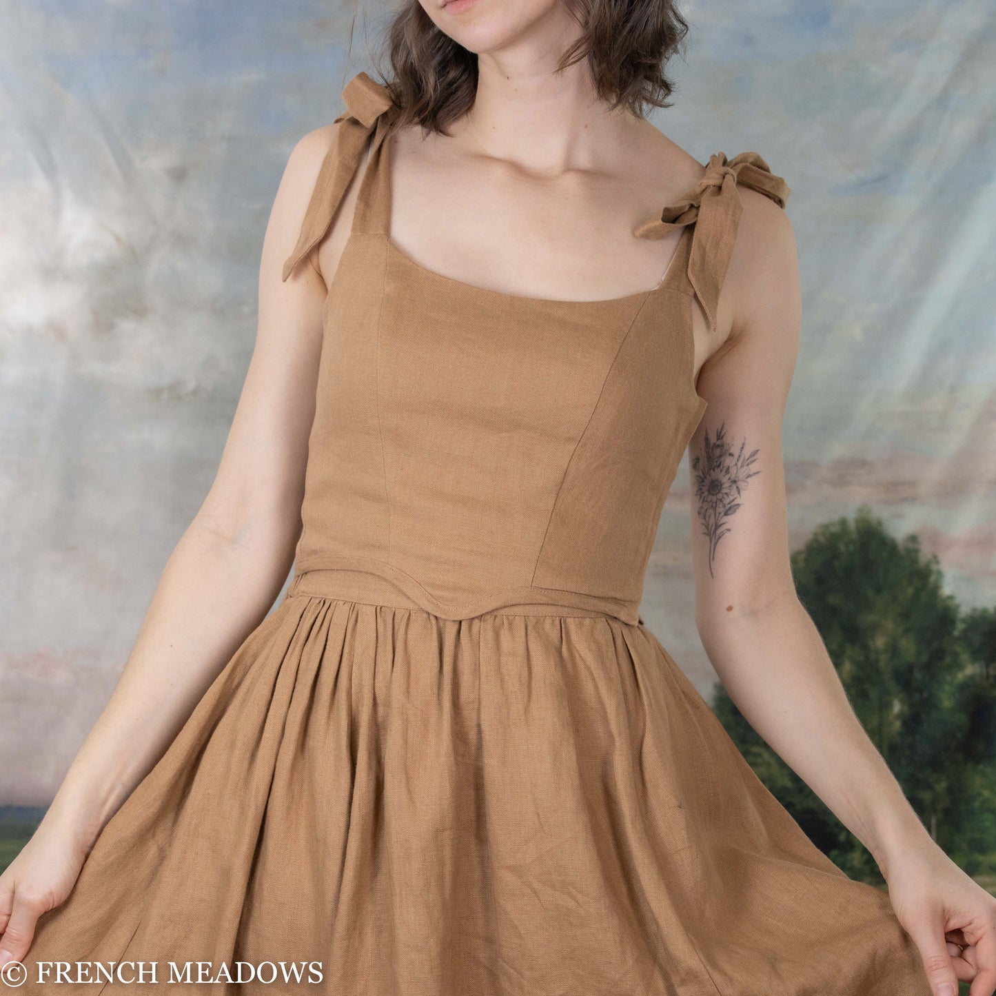 model wearing light brown bustier top with matching linen skirt