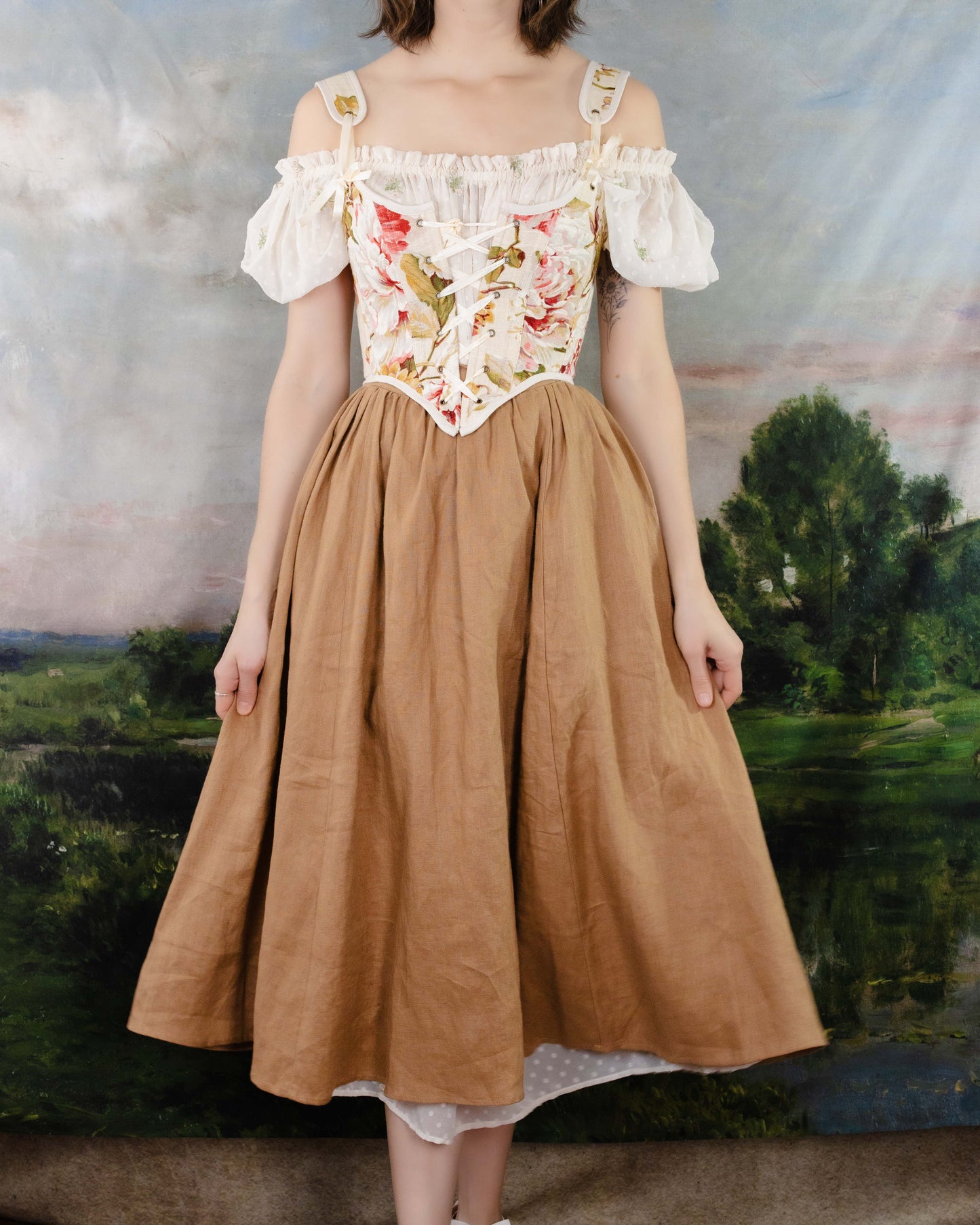 a complete renaissance faire outfit featuring a pink floral corset paired with a ginger linen renaissance skirt and chemise dress