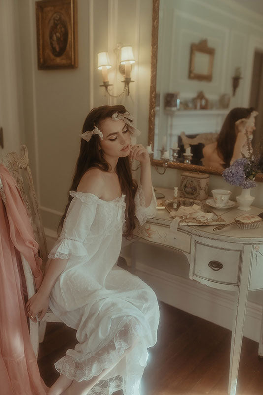 girl drinking tea in a white vintage nightgown