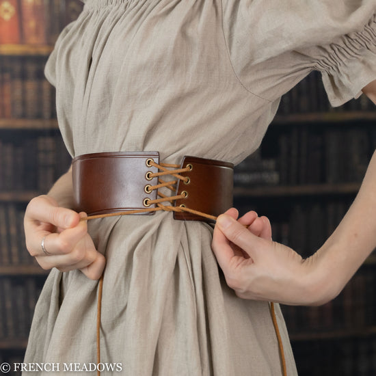 detail view of tie up corset lacing on side of leather waist belt