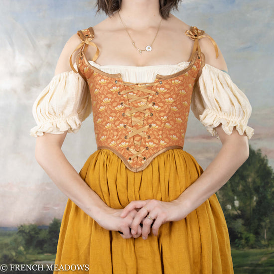 a model wearing an orange and yellow corset dress for a renaissance faire costume