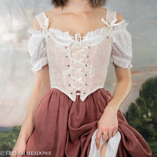 model wearing a pink corset paired with a rose colored linen skirt