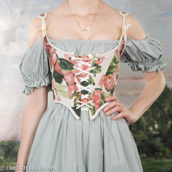 model wearing pink floral corset over a green fairy dress