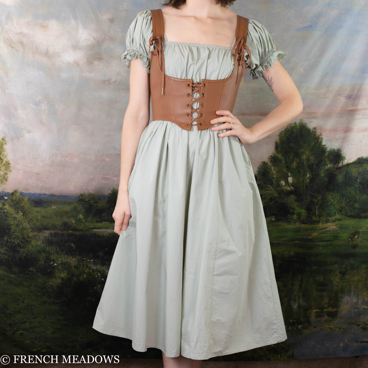 Load image into Gallery viewer, model wearing a green dress with a leather corset harness on top
