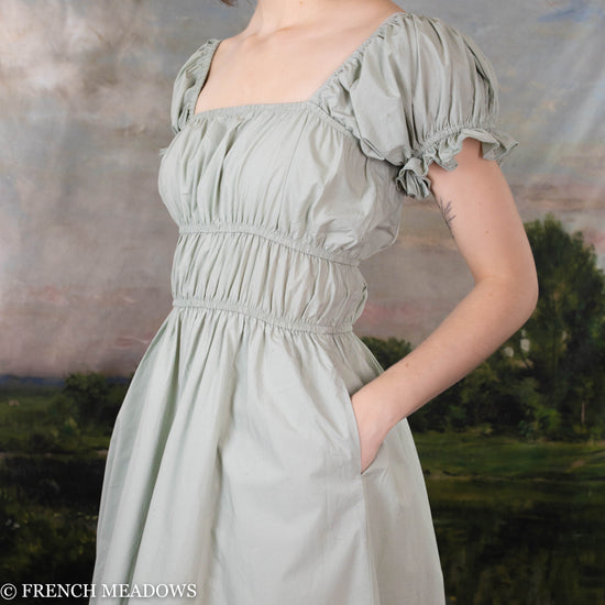 side view of the milkmaid silhouette of the green cotton milkmaid dress showing in-seam pockets details