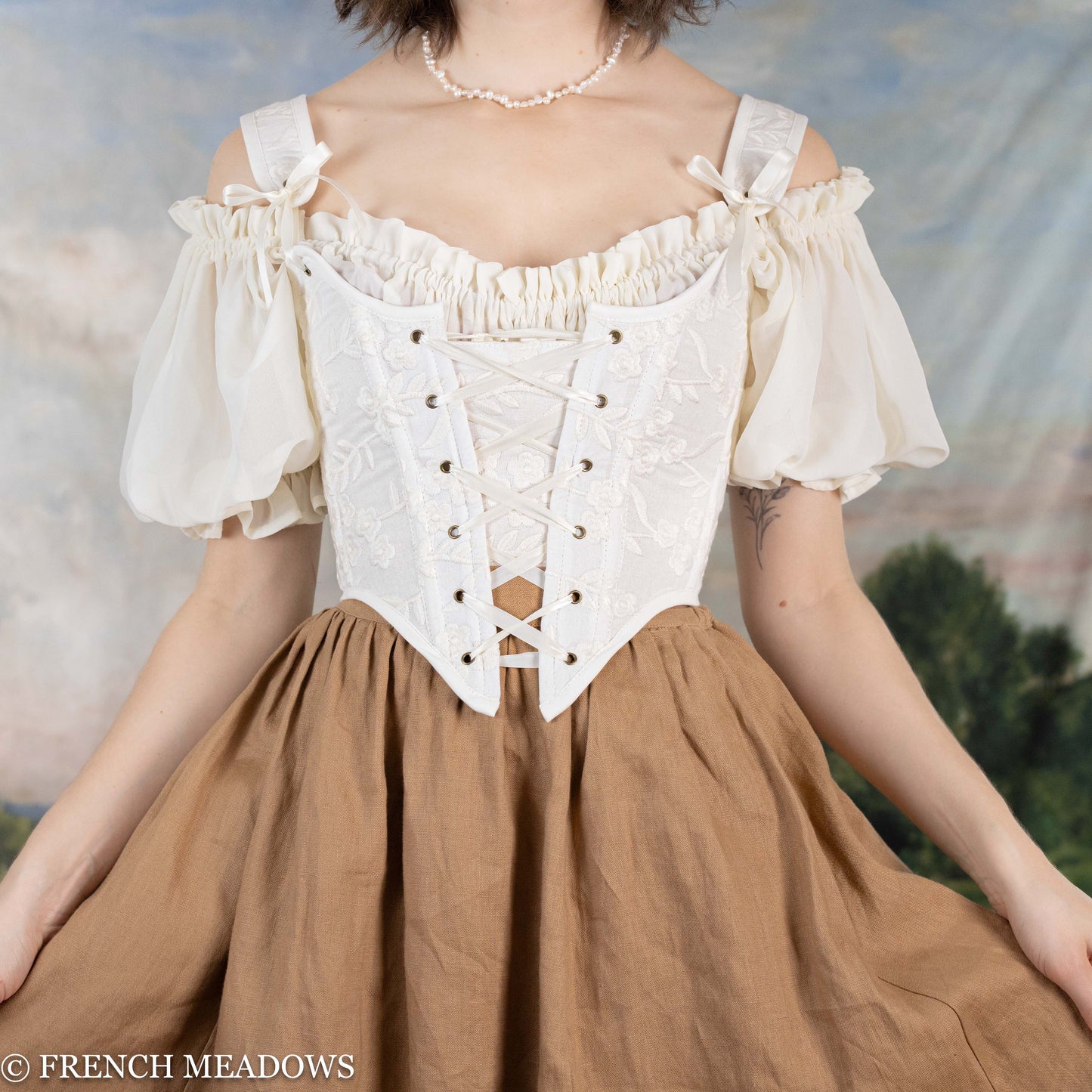 model wearing white floral corset with brown linen skirt
