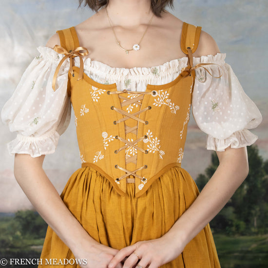 model wearing a yellow floral corset top