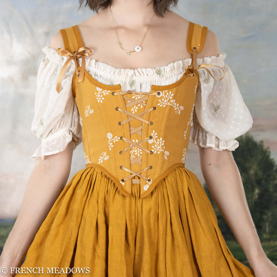 model wearing a yellow floral corset with a yellow linen skirt
