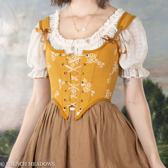 model wearing the yellow corset top paired with a light brown ginger linen skirt